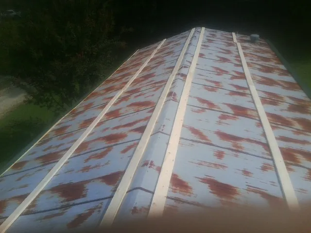 Rusted metal roof panels with new wood purlins before replacement — Storm Damage Roof Repair in Blanch by Roofing Brothers