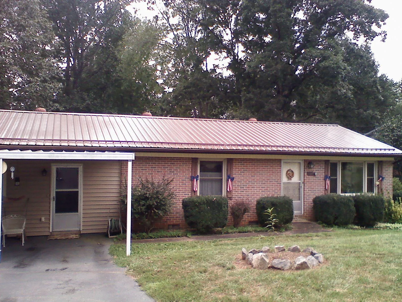 Bronze metal roof and carport on a brick ranch home — Roof Repair work by our crew in Blanch