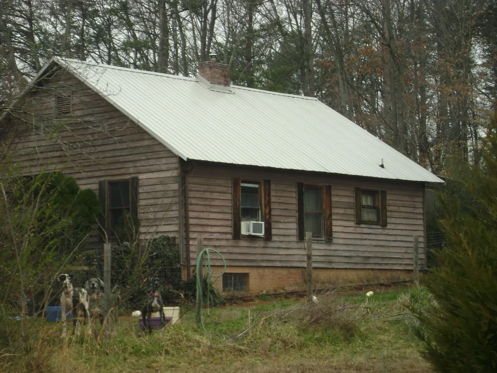 White metal roof on an old wood sided farmhouse, from a Metal Roof Installation job in Blanch